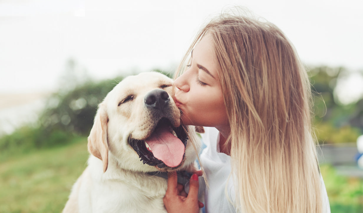 MYBUDDY Nahrungsergänzungsmittel für Hunde Frau die einen glücklichen Hund küsst